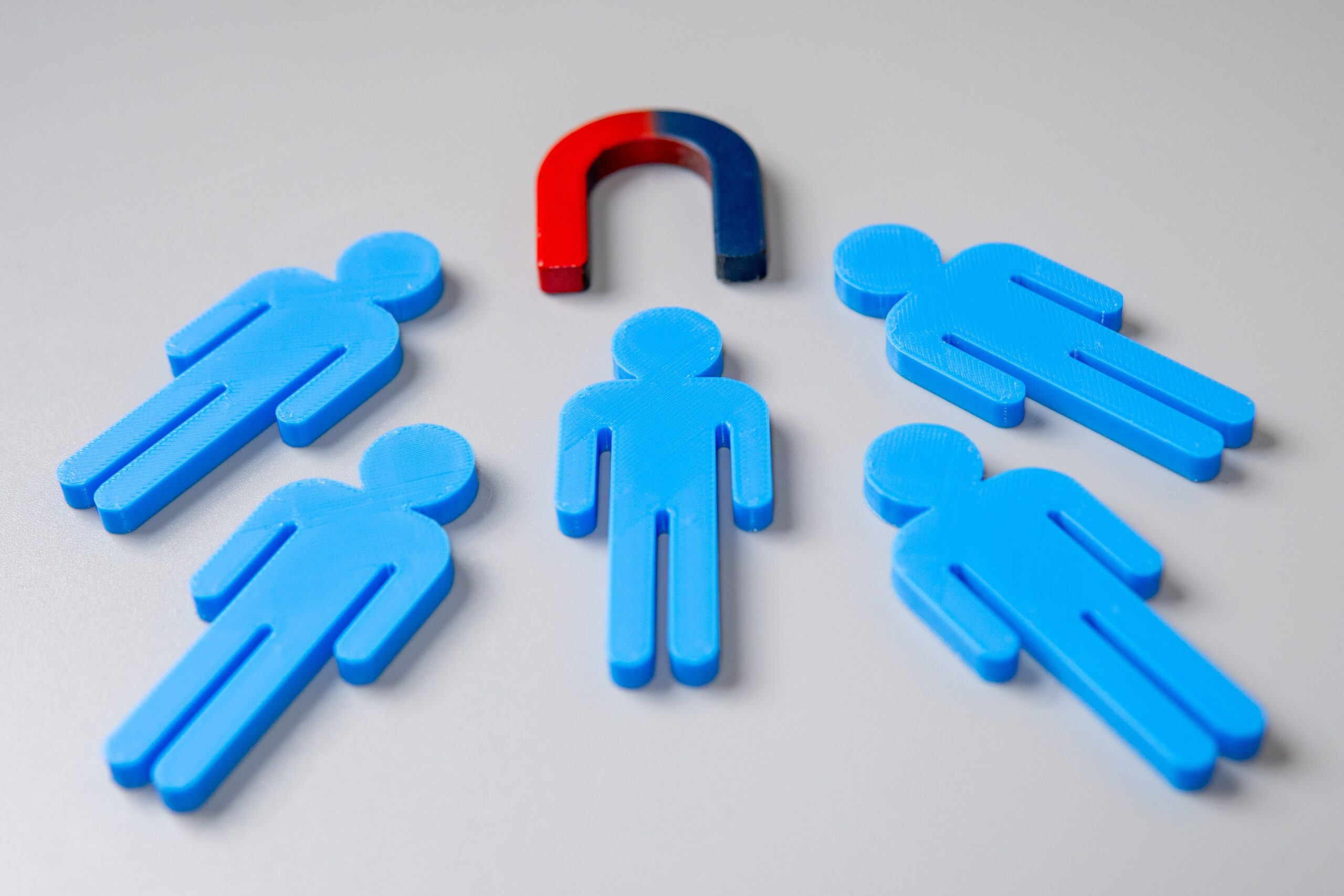 A magnet attracting human figures showing client acquisition.
